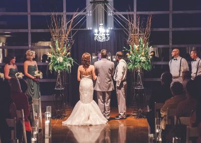 Wedding ceremony under arbor with chandelier